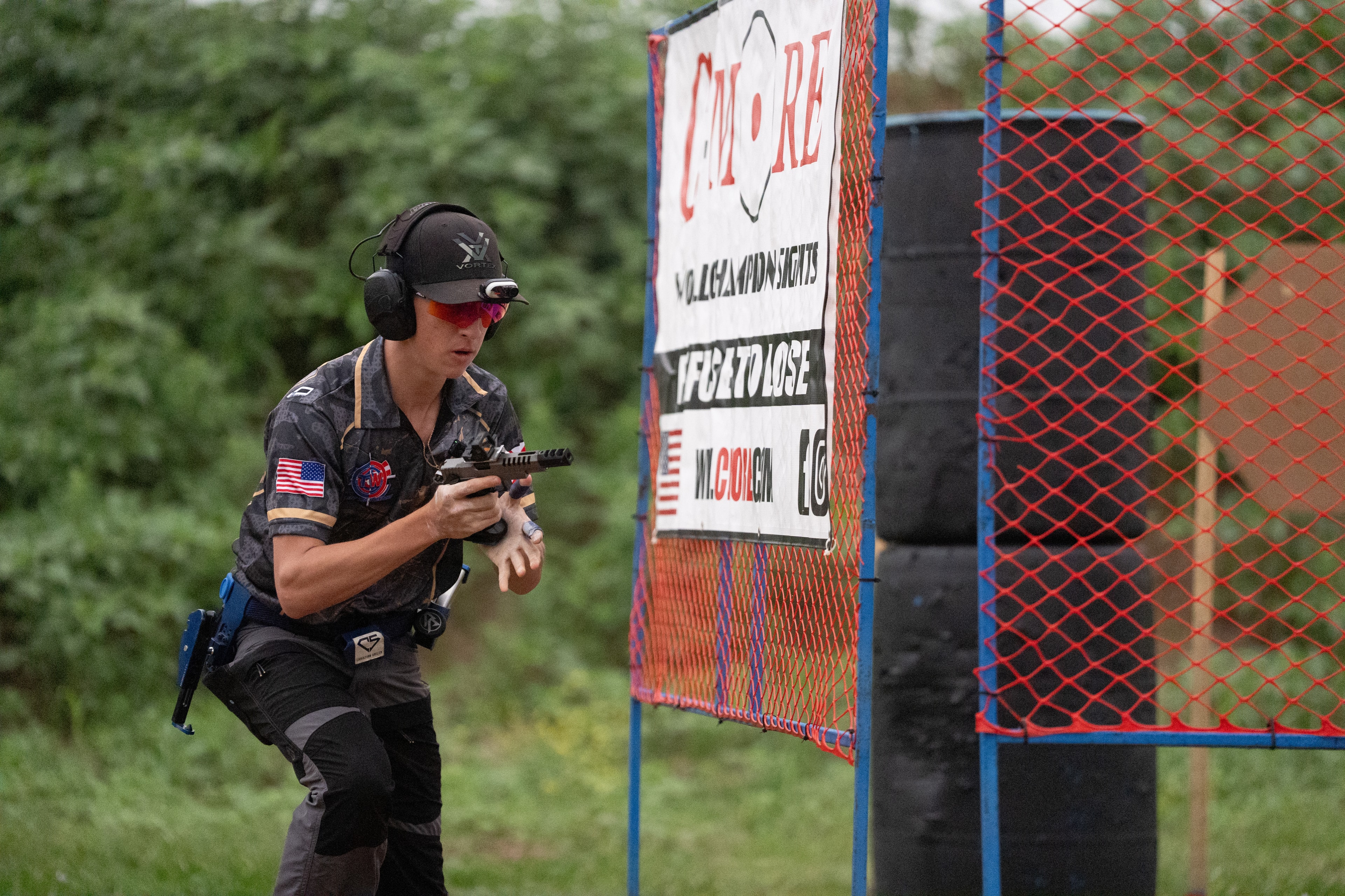 Tripp Wilson moving between positions during a USPSA competition stage, pistol at the ready
